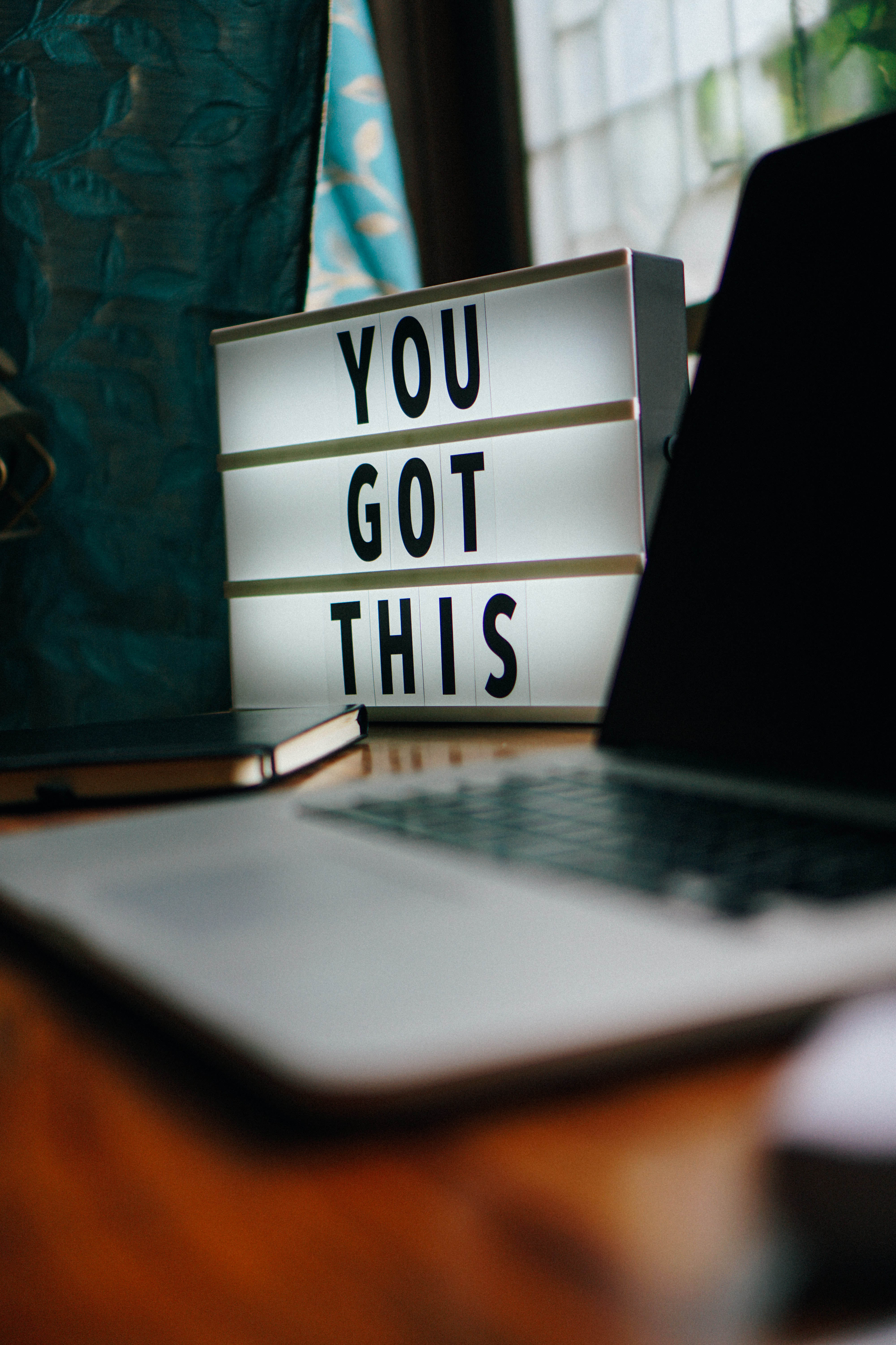 a sign saying "You Got This" next to a lap top